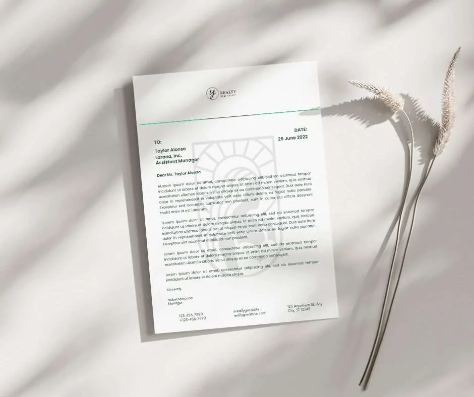 Ylenia Fotzi: la carta intestata YRealty vista dall'alto, accanto a due spighe secche